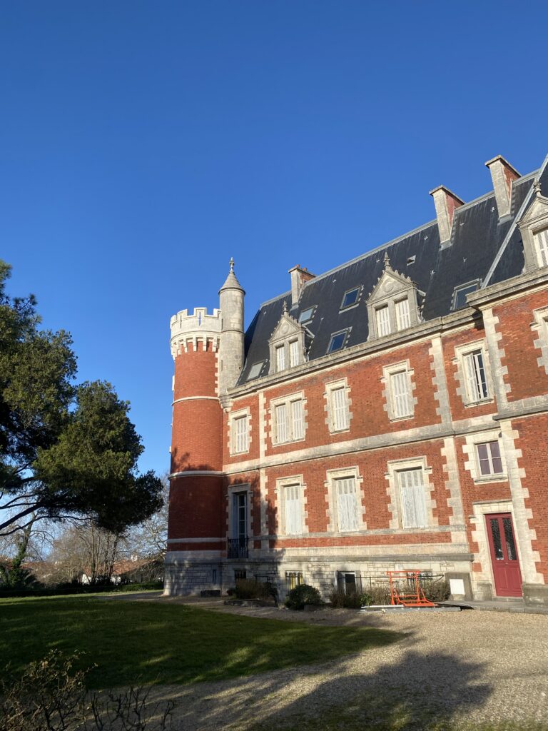 Biarritzi ajalooline villa punastest tellistest torniga kevadises roheluses