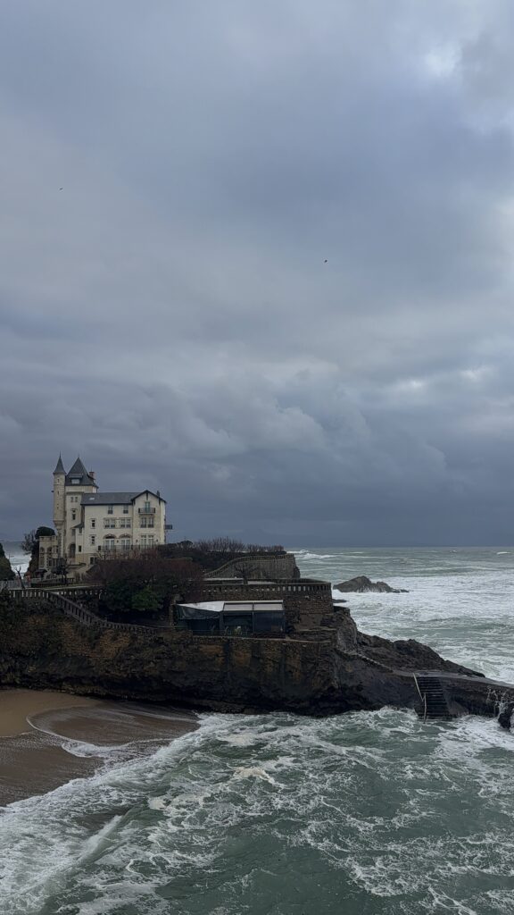 Biarritzi rannakalju vaade – lained, ajaloolised hooned ja dramaatiline pilves taevas