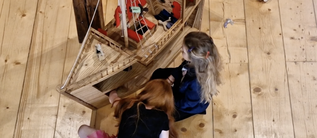 Laps mängib puust mänguasjadega Tartu Mänguasjamuuseumi mängutoas