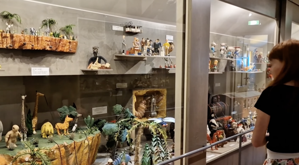 Tüdruk vaatab Eesti nukufilmide nukkude vitriini Tartu Mänguasjamuuseumis