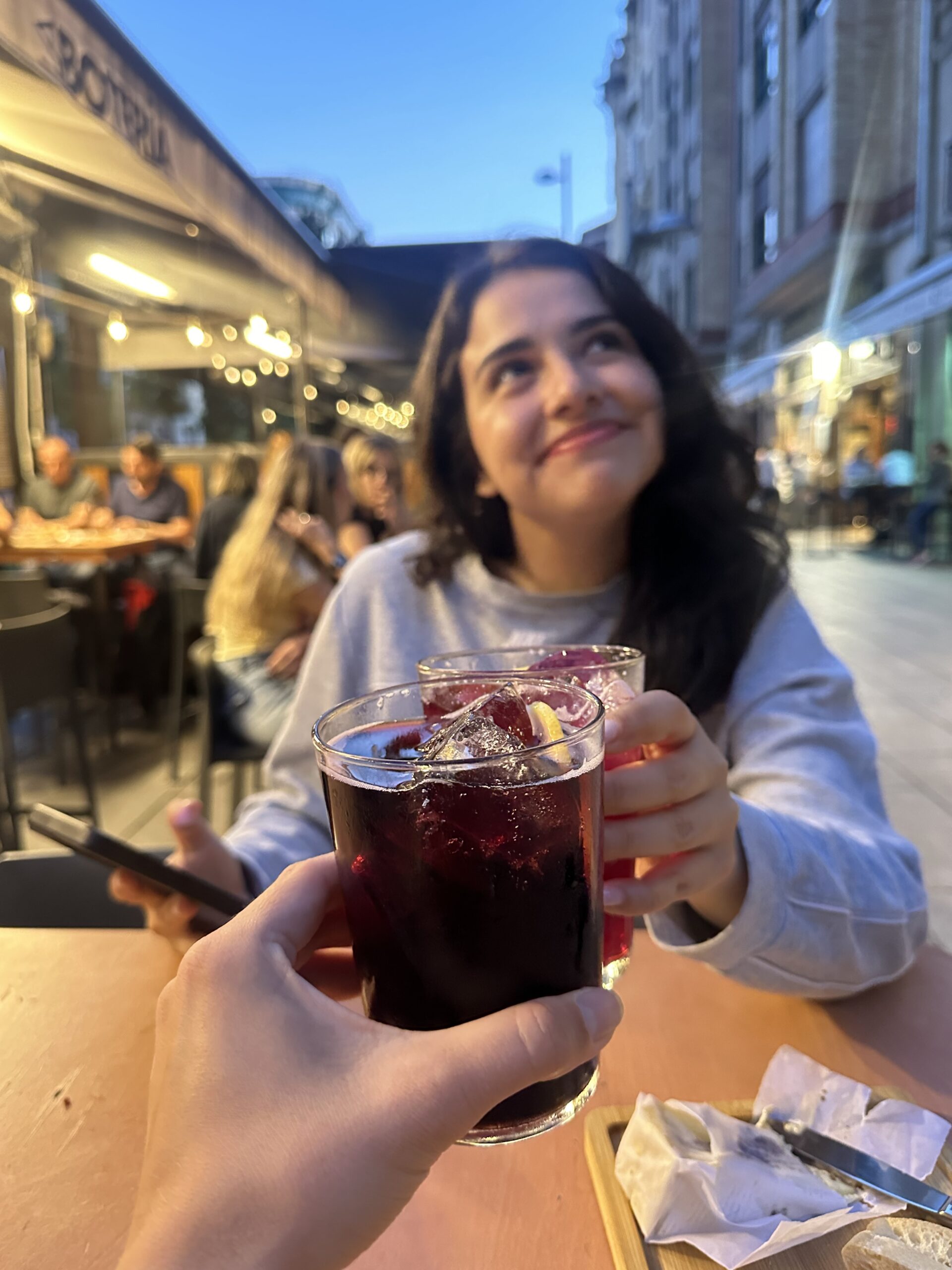 Adriana hymyilee juoman kanssa Liman ravintolassa