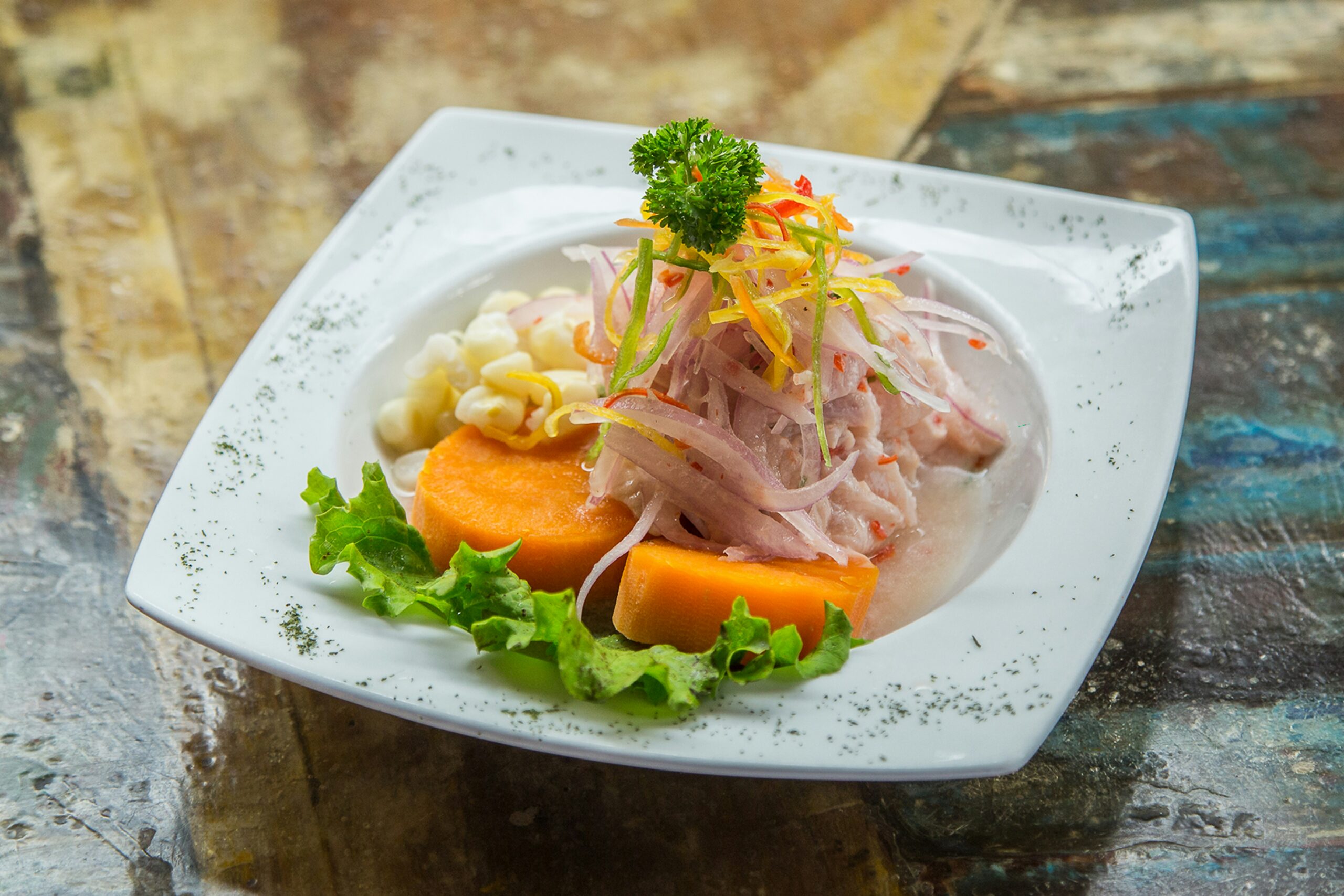 Aseteltu ceviche bataatin, maissin ja punasipulin kera