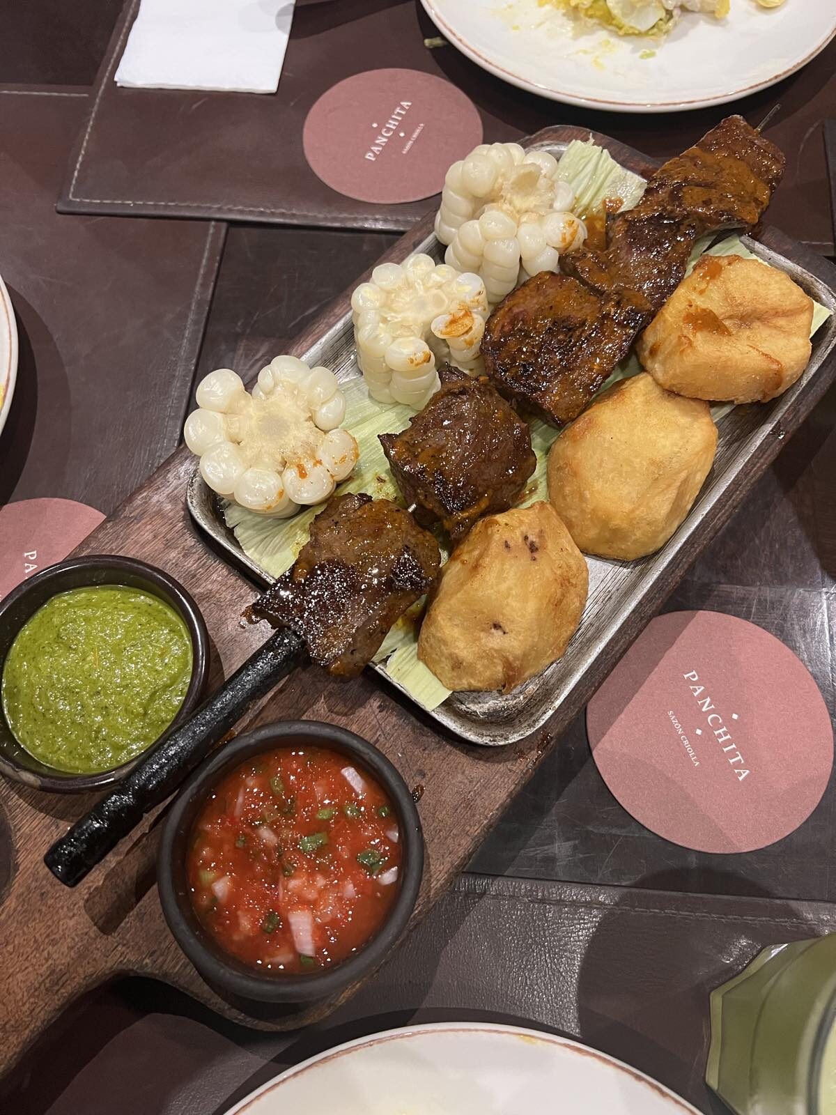 Anticuchos-vartaita ja paistettuja lisukkeita kahdella kastikkeella