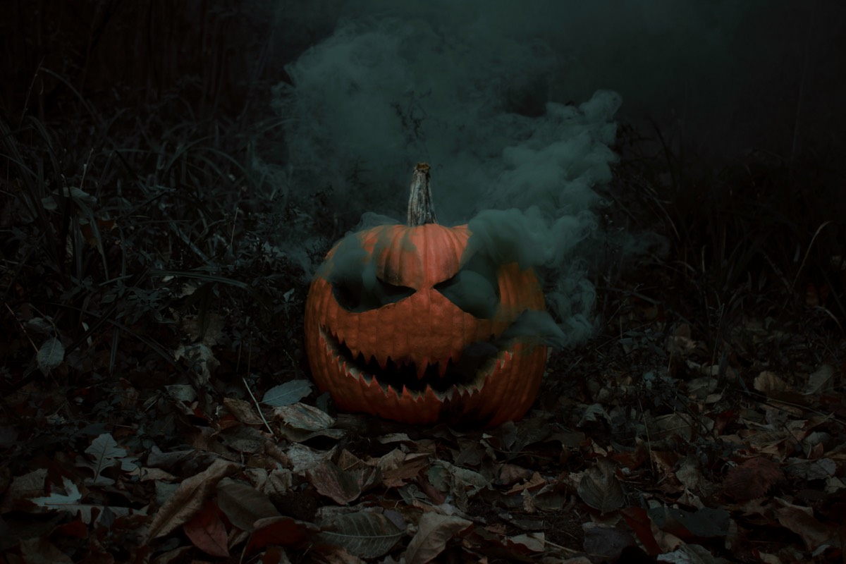 Suitsev kõrvitsalatern pimedas sügismetsas Halloweeni õhtul
