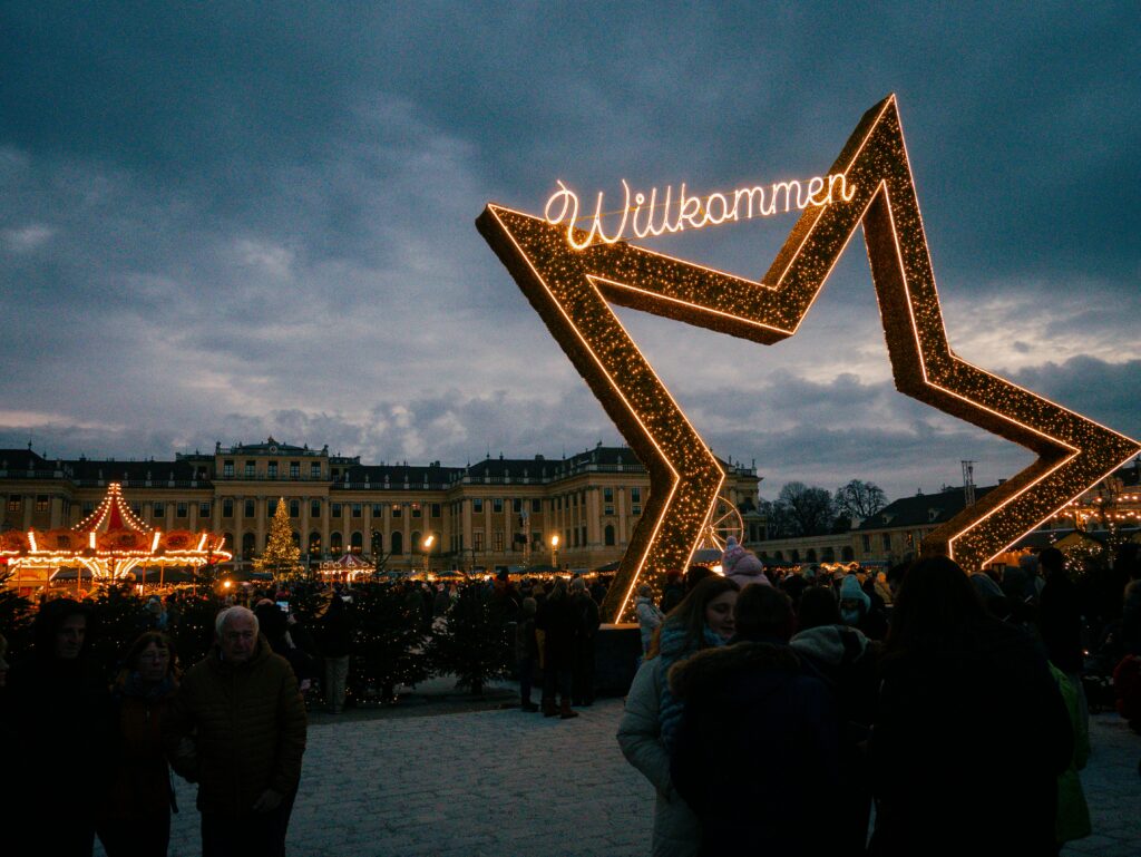 Illuminated Willkommen star at the Schönbrunn Palace Christmas market in Vienna